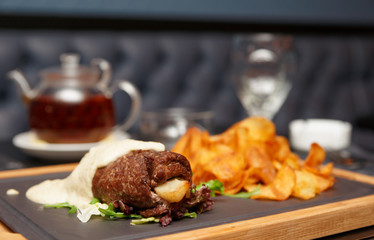 Meat rolls with white sauce on pub table