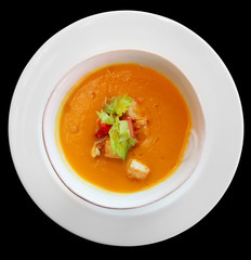 Pumpkin soup in plate shot from above, isolated