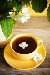 Cup of tea and a bouquet of blooming Jasmine