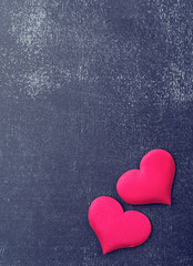 Obraz premium two red hearts on a black board