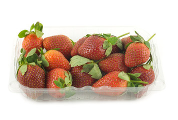 Ripe appetizing red strawberries in plastic container isolated
