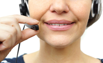Smiling woman with headphones isolated in call center