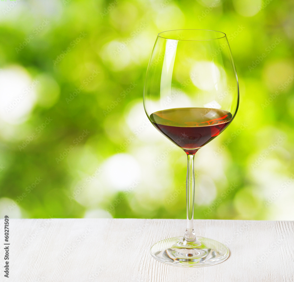 Wall mural Glass of wine on nature background