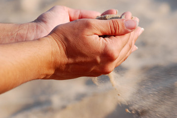 Obraz premium SENTIR LA ARENA DE LA PLAYA CON LAS MANOS.