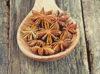 star anise in a spoon on wooden surface