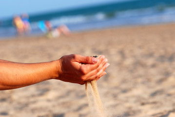SENTIR LA ARENA DE LA PLAYA CON LAS MANOS.