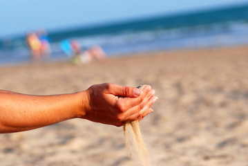 SENTIR LA ARENA DE LA PLAYA CON LAS MANOS.