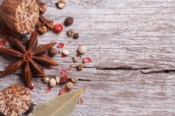 Nutmeg, anise, pepper and bay leaves on old wooden table.