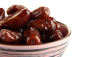 Dried dates in bowl isolated on white