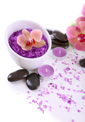 Fototapeta na wymiar Color sea salt in glass bowl, spa stones and orchid flower,