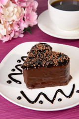 Sweet cake with chocolate on plate on table close-up