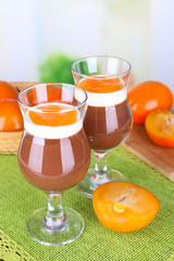 Dessert of chocolate and persimmon on table on light background