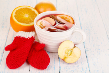 Fragrant mulled wine in bowl on wooden table close-up