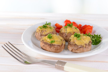 Stuffed mushrooms on plate on table on light background