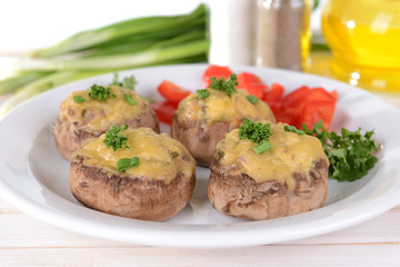 Stuffed mushrooms on plate on table on light background