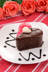 Sweet cake with chocolate on plate on table close-up
