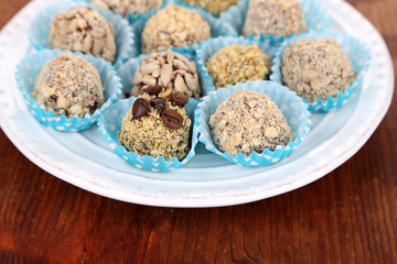 Set of chocolate candies, on plate, on wooden background
