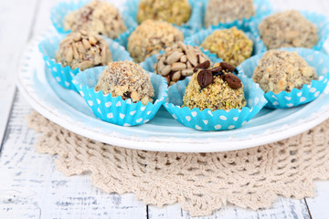 Set of chocolate candies, on plate, on wooden background