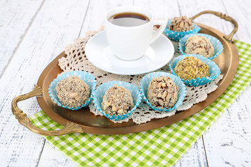 Set of chocolate candies, on tray, on color wooden background