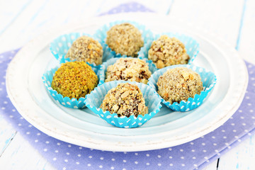 Set of chocolate candies, on plate, on wooden background