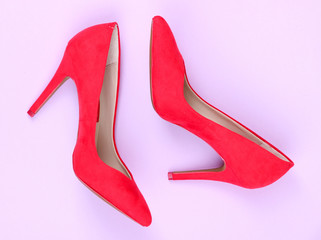Beautiful red female shoes, on purple background