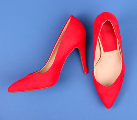Beautiful red female shoes, on blue background