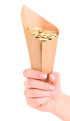 Hand holding paper cornet with pumpkin seeds isolated on white