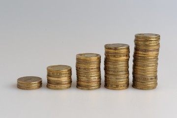 Пять стопок монет на сером фоне