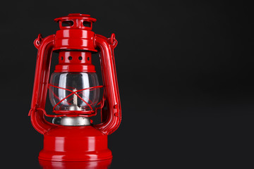 Red kerosene lamp on black background