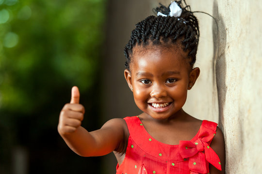 Pretty little african girl showing thumbs up.