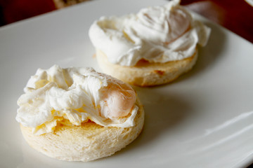 pair of egg benedict on white plate, morning scene