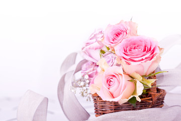 pink roses in brown basket with grey bow