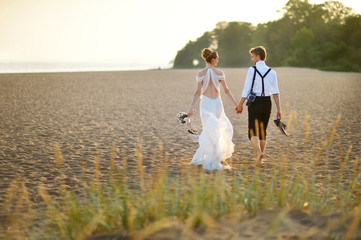 Bride and groom on a beach at sunset