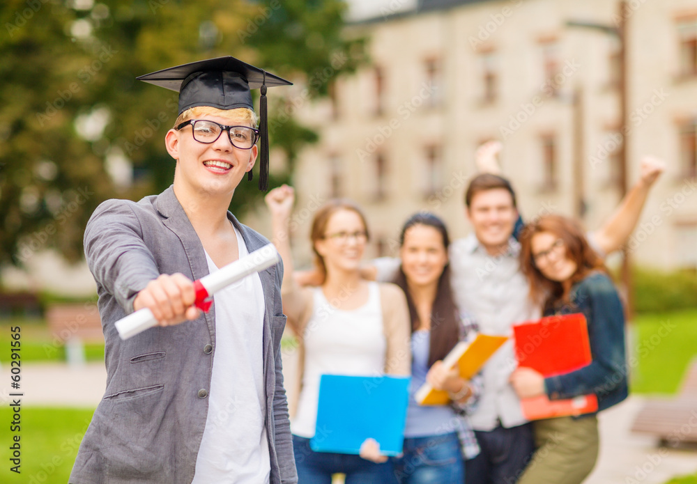 Wall mural smiling teenage boy in corner-cap with diploma