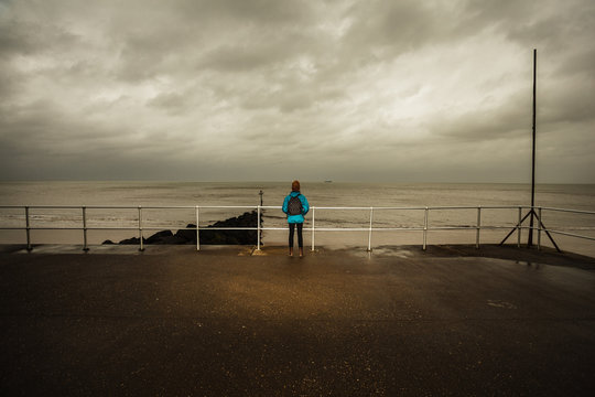 Hiker standing by the sea on a stormy day
