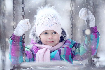 cheerful girl child in the park in winter