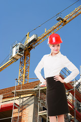Female engineer woman in red safety helmet on construction site