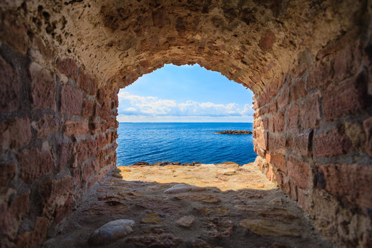 Fototapeta Seascape niebieski morze z ramy okna otwór w starej kamiennej ścianie