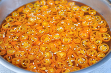 Yellow pickled-chilli mix with vinegar.