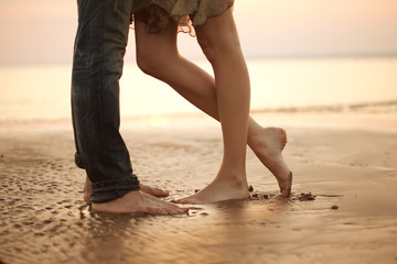 A loving young couple hugging and kissing on the beach. Lovers m - Powered by Adobe