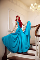 Young woman with luxurious long beautiful red hair in a blue fas
