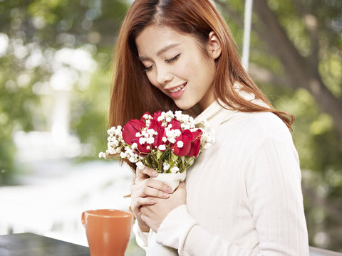 young woman smelling the fragrance of flowers