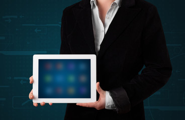 Woman holding a white tablet with blurry apps