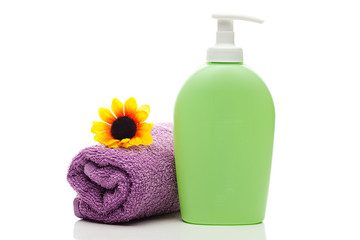 Obraz na płótnie Canvas cosmetic containers,towel and sunflower isolated on white