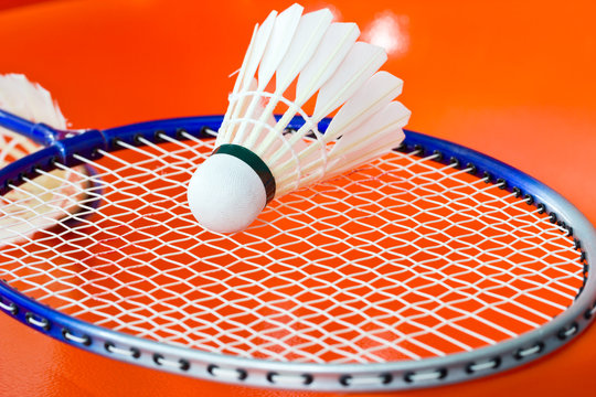 Badminton rackets and shuttlecock isolated on orange background