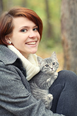 girl and a cat in the autumn park