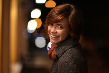 cheerful smiling girl in an autumn night city