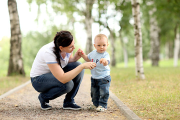 happy young mother playing with baby in the park