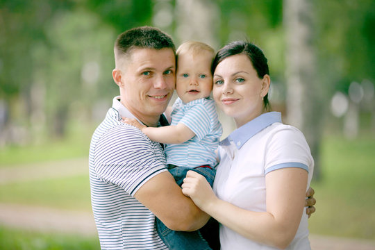 Happy Young Family Mom Dad And Baby In The Park