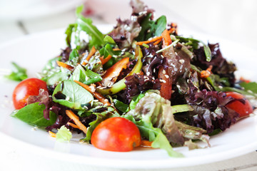 Fresh vegetable salad with arugula on white plate